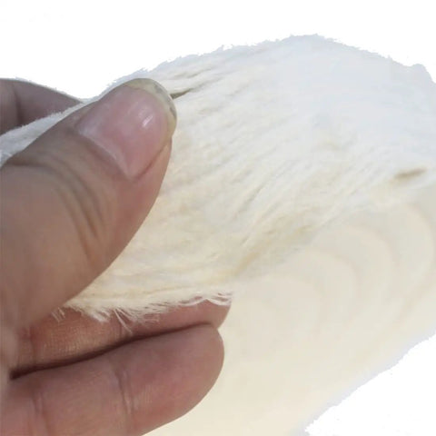 Close-up of a hand holding a Two Pack Beefy Extra Thick White Cotton Buffing Wheels Eight Inch Diameter with Five Eighth Inch Arbor Hole