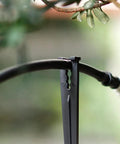 Product image showing a black plastic irrigation stake lifting 1/4 inch drip tubing off the ground. Ideal for garden use.