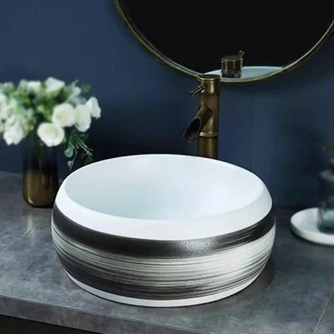 Bathroom Sinks Indoor Countertop Ceramic Basin Outdoor Countertop Washbasin Bathroom Basin Wash Basin Vessel Vanity Sink Bowl Basin in white and black design on gray countertop.