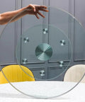 Extra Large 110cm Clear Glass Lazy Susan Turntable held above table with aluminum base for easy rotation.