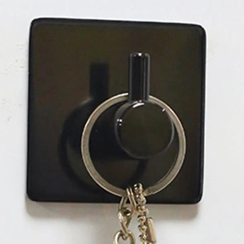 Rock Solid Black Stainless Steel Adhesive Wall Hook For Coats Towels And Umbrellas With No Hassle Peel Stick Mount Zero Drill Setup And Slick Modern Design For Bathrooms And Hallways holding keys on a wall.