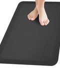 Feet on an Anti Fatigue Standing Mat For Desk And Kitchen, Ergonomic Cushioned Comfort Pad With Waterproof Surface, Non Slip Bottom, Beveled Edge.