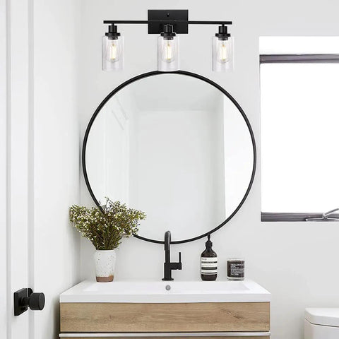 Three Light Matte Black Farmhouse Vanity Light With Seeded Glass Wall Sconce above a bathroom mirror and sink