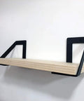 Heavy Hitter Iron Corner Brackets For Floating Shelves Built Tough Right Angle Wall Support Takes A Beating Holds Up To 176 Pounds Pair Of Two Matte Black supporting a wooden shelf.