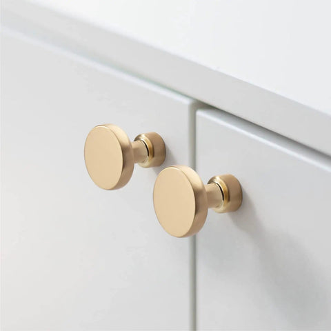 10 Pack Brushed Brass Cabinet Knobs 1-1/4 Inch Gold Drawer Knobs installed on white kitchen cabinet doors.