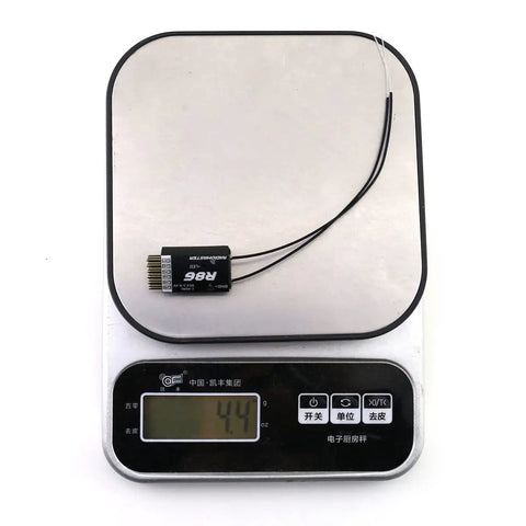 R86 6Ch Receiver With PWM And SBUS Output For FrSky D8 Compatibility Ideal For RC FPV Drones And Transmitters 4.5V-8.4V Power 2400-2483.5MHz Operation Lightweight Black Module on a digital scale