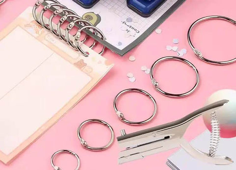 Tough As Nails Single Hole Punch For Crafts And Scrapbooks, Quarter Inch Hole Puncher In Zinc Alloy, with rings on a craft table.