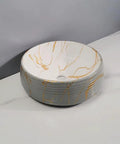 Round ceramic bathroom vessel sink with gold marbling, ideal for home or hotel counter basin use.