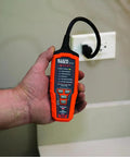 Person holding a Pro Grade AFCI and GFCI Outlet Tester for North American Receptacles near wall socket.
