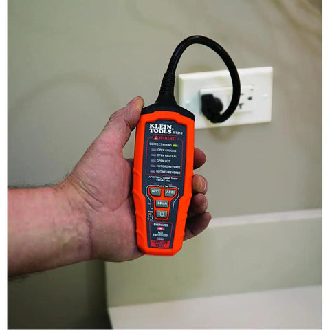 Person holding a Pro Grade AFCI and GFCI Outlet Tester for North American Receptacles near wall socket.