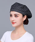 Custom Logo Chef Beret And Barista Hat For Kitchen Crew Offering Breathable Embroidered Name Cook Skullcap In Sleek Black Slick Go To Food Service Gear worn by a woman.