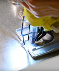 Close-up of a jigsaw with blade installed cutting metal on a workbench.