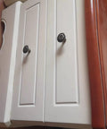 Close-up of vintage flower shape cabinet knobs set of 6 bronze tone metal drawer pull handles with screws installed on white cabinet