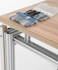 Ultimate M5 T Nut And Black Screw Kit For 6mm T Slot Aluminum Extrusion on wooden table with open case showing components