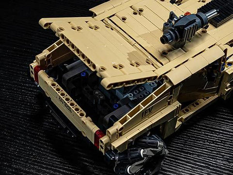 Close-up of technic RC Hummer kit showcasing open trunk detail and Mecanum wheels on a dark surface.