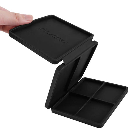 Hand holding a black Portable Tri Fold Silicone Tool Tray With Magnetic Sheets Included Heat Resistant And Flame Retardant Durable Silicone