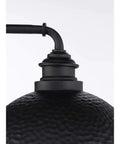 Close-up of Englewood Collection 1 Light Farmhouse Outdoor Post Lantern in textured black with hammered steel and pipe arm.