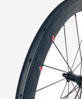 Close-up of Carbon Road Bicycle Wheelset Clincher 50mm Deep Rim Basalt Brake Surface 3K Weave With Novatec ABG Hub.