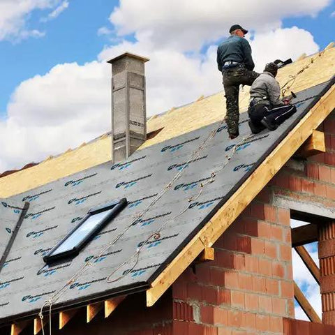 Workers installing Heavy Hitter Synthetic Roof Underlayment Backed By A Lifetime Warranty For Tough Roof Replacement Jobs on a roof.