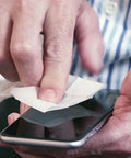 ZEISS pre-moistened screen-cleaning wipe used on smartphone; close-up view