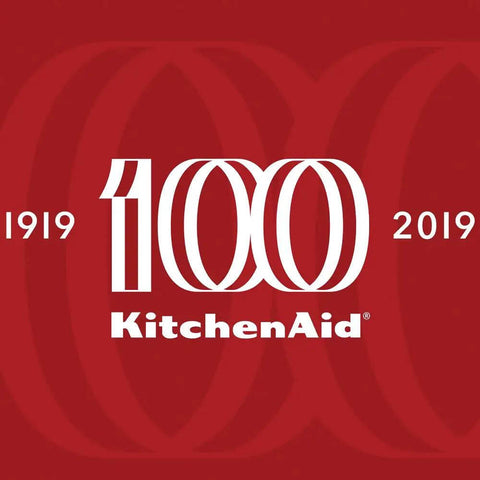 Limited Edition Queen Of Hearts Corded Hand Blender In Bold Passion Red with KitchenAid 100th Anniversary logo in white on red background.
