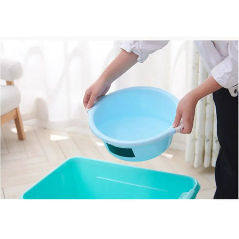 Heavy Duty Black PVC Repair Sealant Tape Waterproofs Leaks And Cracks Instantly For Kitchen Pipes Drains And Bathroom Fixings With Super Sticky Adhesion That Holds Tight Without Dripping Or Peeling Off No Matter How Wet It Gets So You Can Banish Those. Light blue plastic bowl held by a person above a green container in a bright room.