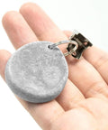 Close-up of No Slip Marble Tablecloth Weights With Clips, showing grey pendant stone and metal clip in hand.