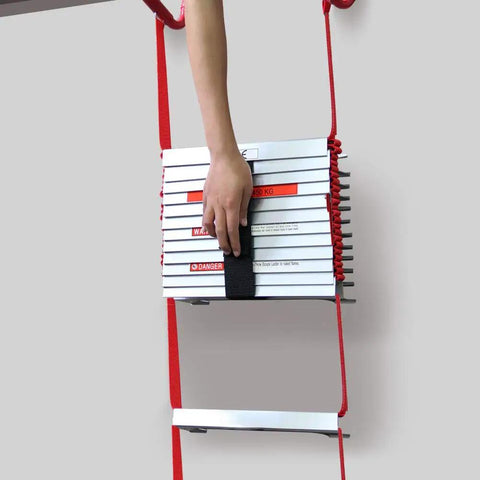 Hand holding a folded Retractable 3-Story Fire Escape Ladder 25 Feet For Home Emergency Safety with red ropes and silver rungs