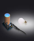 Music Tesla Coil Desktop Ornament With Three Arc Effects Lightning Maker Kit Bundle Includes Two Tiny DIY Tesla Coil Kits Blue Silver Gift For Science Lovers STEM Toy shown with light bulb.