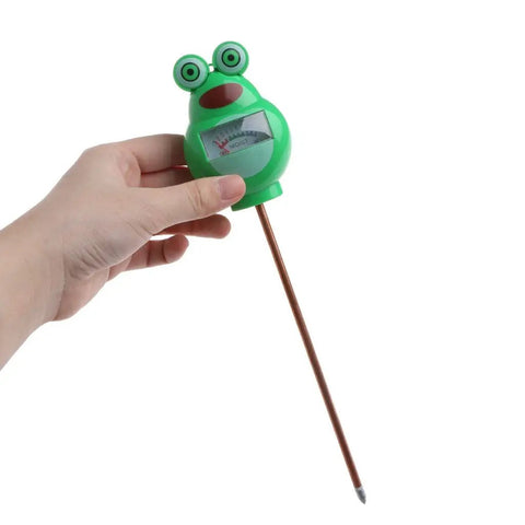 Hand holding a frog-shaped Soil Moisture Tester Kit For Plants And Lawns, Indoor Outdoor Humidity Meter, green ABS material