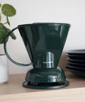 Pour Over Coffee Dripper Kit With Filters 18 Ounce Capacity BPA Free Plastic Dark Green Includes 100 Filters Easy Clean Mess Free Brew At Home Barista Style on a kitchen counter with plant