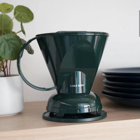 Pour Over Coffee Dripper Kit With Filters 18 Ounce Capacity BPA Free Plastic Dark Green Includes 100 Filters Easy Clean Mess Free Brew At Home Barista Style on a kitchen counter with plant