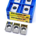 Front view of APKT milling inserts in a blue plastic organizer; yellow label APKT1604PDFR-MA H01, with three silver inserts.