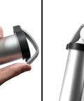 Aluminum Shag Tube Golf Ball Shagger And Dispenser with rubber strap, side view, hand holding tube next to easy pick end with golf ball.