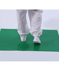 Heavy Duty Tacky Floor Mats 300 Total Sheets with user stepping on green mat designed to trap dirt and grime at cleanroom entry.