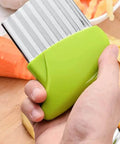 Front view of green-handled stainless steel crinkle-cutting tool with wavy blade for vegetables