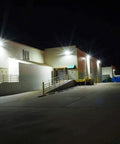 120W Dusk To Dawn LED Wall Pack Light With Photocell, 15840 Lumens, illuminating a large warehouse exterior at night