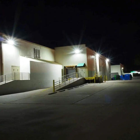 120W Dusk To Dawn LED Wall Pack Light With Photocell, 15840 Lumens, illuminating a large warehouse exterior at night
