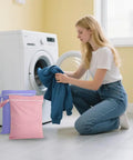 Woman using Two Pack Reusable Wet Bags With Handles And Zippers Ultra Lightweight Waterproof Cloth Diaper And Laundry Bags in pink and purple