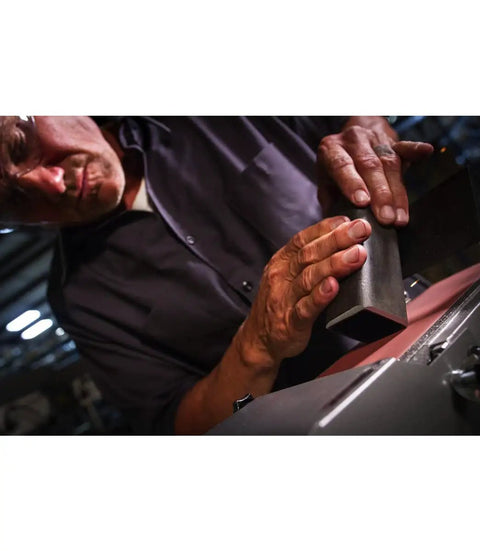 Close-up of a person using a Built Like A Tank One Horsepower Variable Speed Disc Grinder And Belt Sander Combo for metal work.