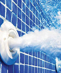 Pool jet nozzle, white circular fixture on blue tiled pool wall spraying water.