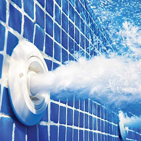 Pool jet nozzle, white circular fixture on blue tiled pool wall spraying water.