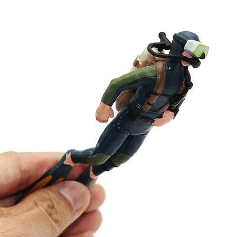Hand-holding a diver ornament from the 2 Pack Aquarium Diver Ornaments Set For Floating Fish Tank Decor Lit Little Divers, detailed view.