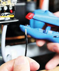 Using the 3-In-1 Automatic Wire Stripper And Ferrule Crimper With Side Cutter For 10-20 AWG on an electrical wire.