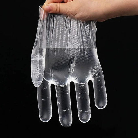 Close-up of a clear disposable plastic food-prep glove worn on a hand.