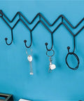 Black Wrought Iron Wall Mount Coat Hooks With Smooth Polish Heavy Duty Key Hangers on blue wall holding keys and accessories.