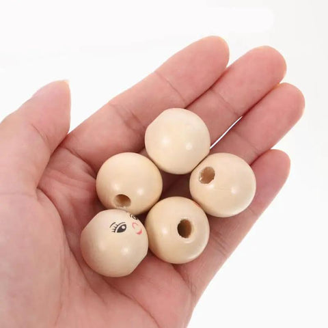 Hand holding Round Wooden Smile Face Beads Set, 50 Pieces Doll Head Wood Beads, 14mm diameter with holes for DIY crafts