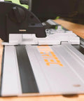Badass 110 Inch Track Saw Guide Rail Extension Kit With Two 55 Inch Aluminum Extrusion Rails Dual Quick Release Mounting Clamps And Seamless Track Connectors Tailored For Makita Or Festool Shop Rats close-up of track saw on aluminum track.