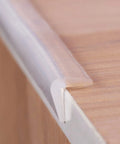 Clear Silicone Corner Guards For Baby Proofing Home Furniture, 3 Feet Flexible Peel And Stick Edge Protectors Nearly Invisible No Fuss Ultra Safe Trim on a wooden countertop.