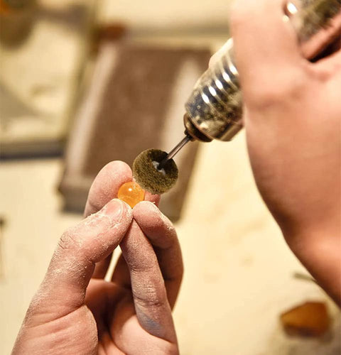 Buffing wheel on a rotary tool polishing an orange bead